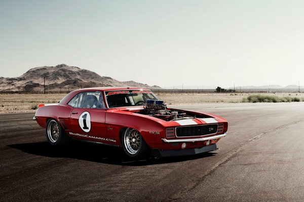 Chevrolet Camaro on the highway at sunset