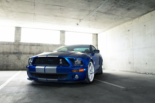 Blue Ford Mustang drives fast through the city