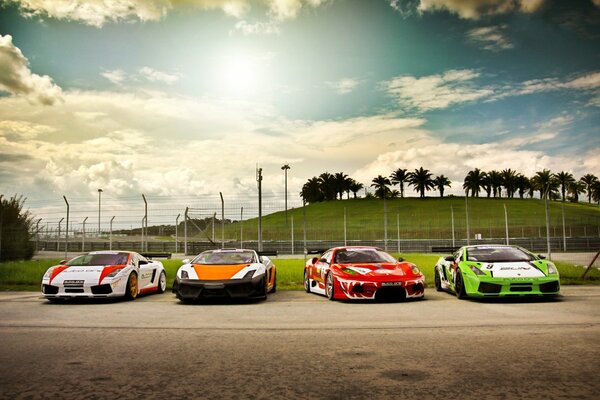 Три автомобиля Lamborghini и одна машина марки Ferrari с гоночными цветовыми схемами