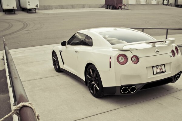 Photo wallpaper Nissan GTR white drives off the ramp