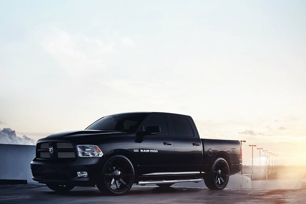 Black jeep pickup truck rides on sunset background