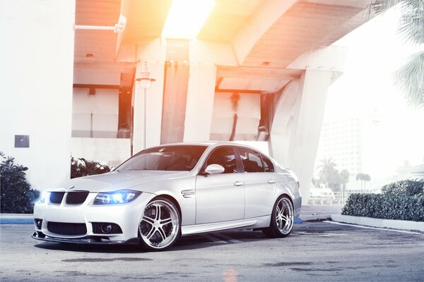 Silver BMW with headlights on in a beautiful light