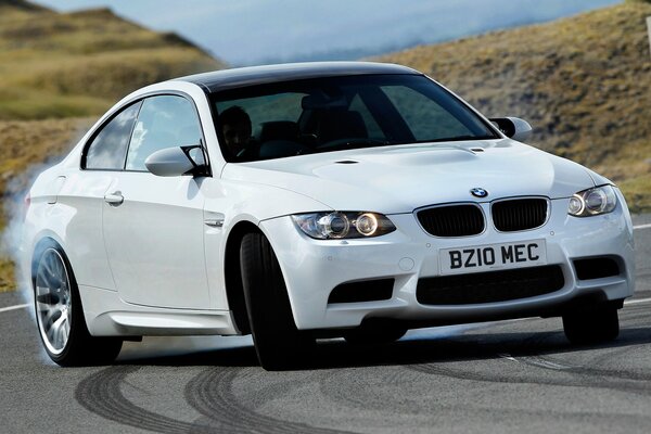 BMW blanco realiza un truco de derrape con humo