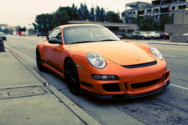 Porsche orange sur fond de rue