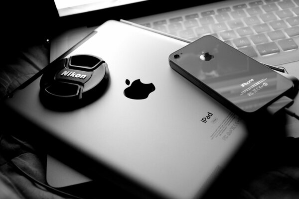 Айпад , айфон и крышка от объектива никог на клавиатуре ноутбука