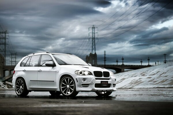 Weißes Auto bmw x5 auf dem Hintergrund der Wolken