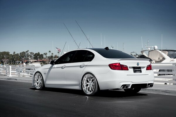 A white BMW f10 is standing on the dock