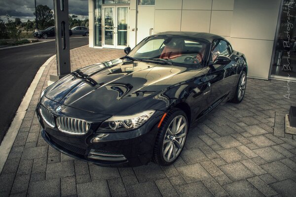 There is a beautiful black car on the road