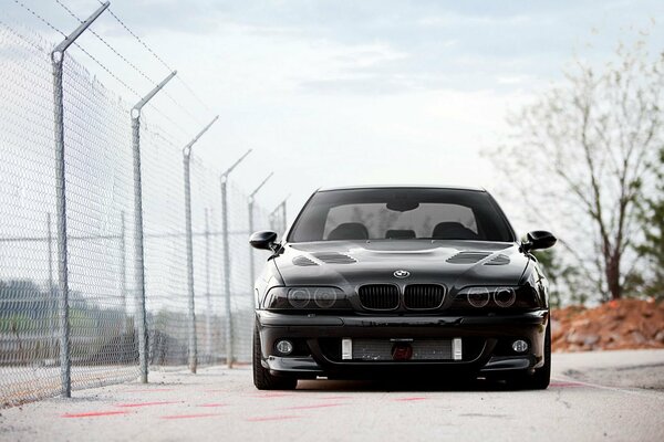 Coche BMW negro cerca de la escuela