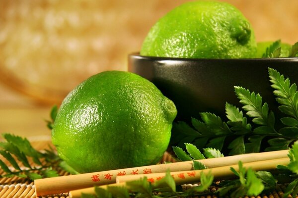 Lime in una tazza accanto a bastoncini cinesi