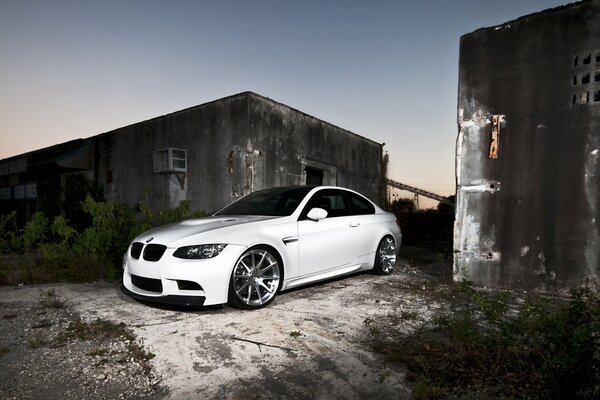 White BMW around abandoned buildings