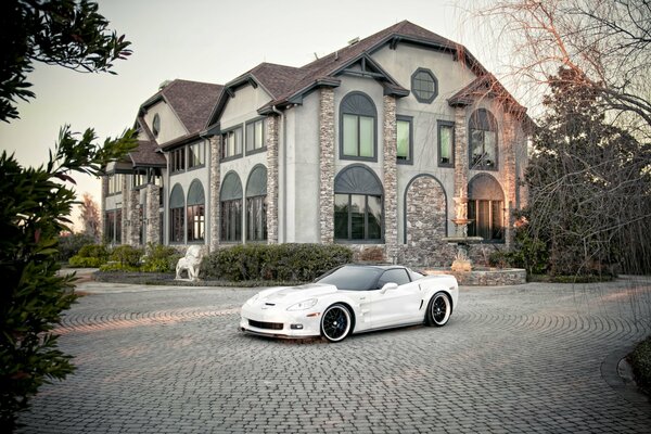 Chevrolet Corvette couleur blanche sur fond de manoir