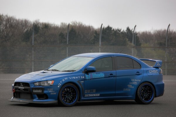 Blue mitsubishi lancer on the sky background