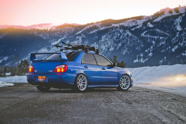 Azul Subaru en el fondo del paisaje de montaña de invierno