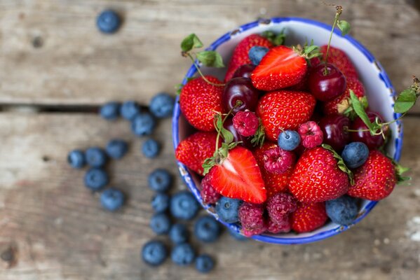 Erdbeeren, Himbeeren, Blaubeeren in einer tiefen Tasse