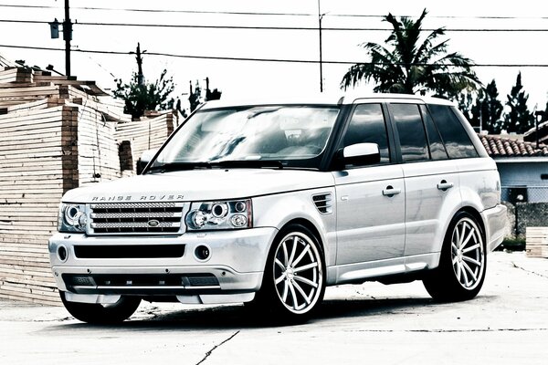 A white tuned Land Rover is standing still
