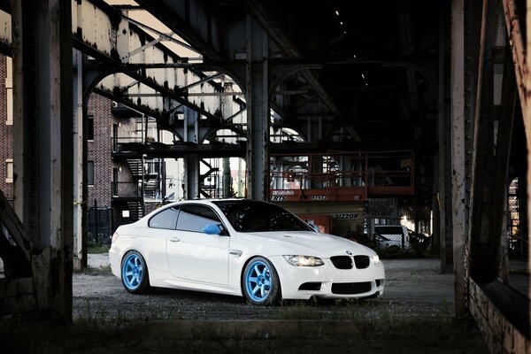 Bmw blanco en el puente frente a los edificios de la ciudad