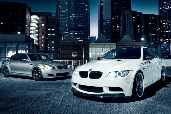 Due BMW grigio e bianco. Gli episodi 5 e 3 sono sullo sfondo della città