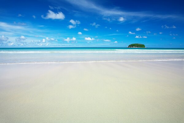 Vista desde una playa de arena blanca a una isla paradisíaca cercana