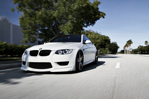 BMW blanco monta en la carretera recta