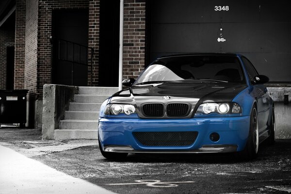 There is a blue, beautiful car, next to the stairs