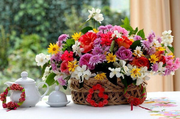 Composition of geraniums, roses and jasmine on the table