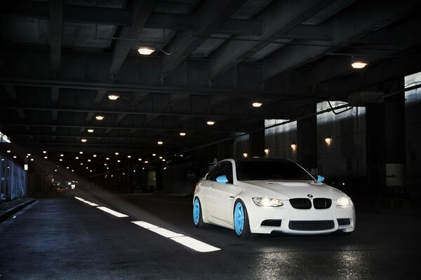 BMW blanco en las Llantas azules en el camino