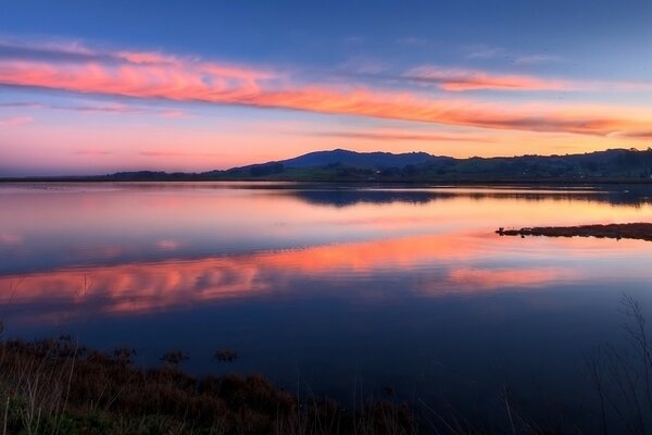 Lago azul que se fusiona con el cielo al atardecer