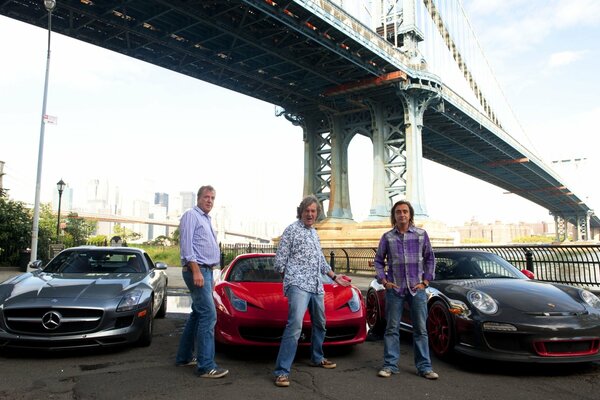Männer im Hintergrund von Autos unter einer Brücke
