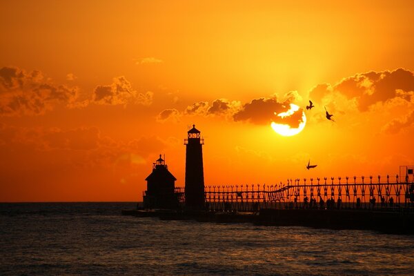 Faro en el fondo del cielo rojo-naranja