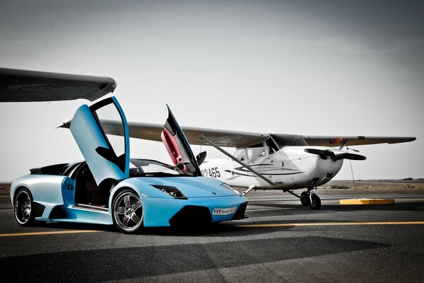 Leerer Lamborghini mit angehobenen Türen neben dem Flugzeug
