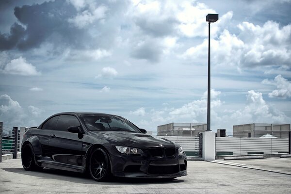 Noir bmw cabriolet sous le ciel avec des nuages