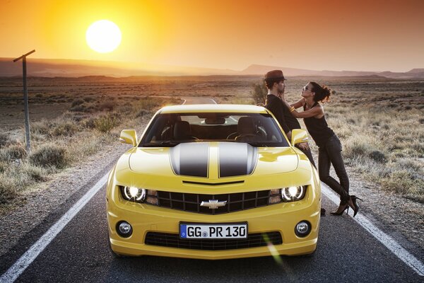 Coppia di amanti in Chevrolet Camaro giallo