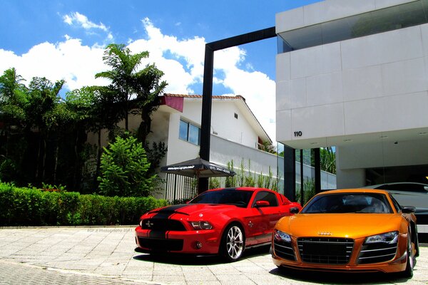 Coches blancos, naranjas y rojos en el fondo de la casa