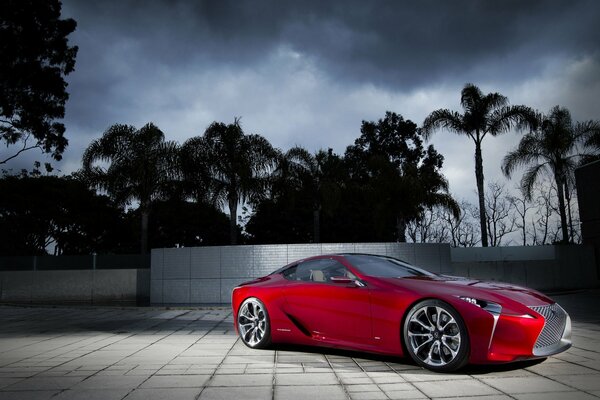 Lexus rouge sur fond de paysage avec palmiers