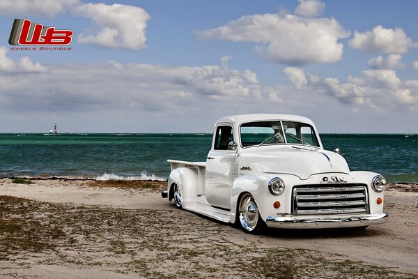 Ein getunter weißer Lowrider am Strand am Meer