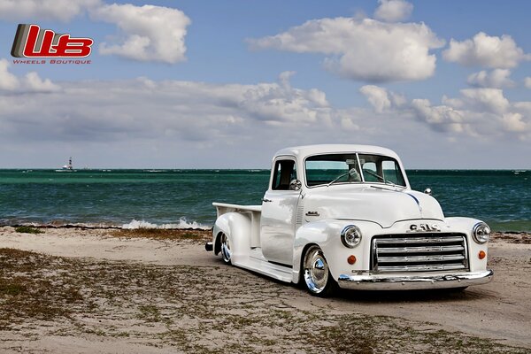 Tuned white lowrider on the beach by the sea