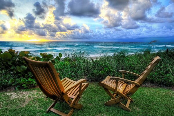 Salida del sol, frente al mar con dos sillas