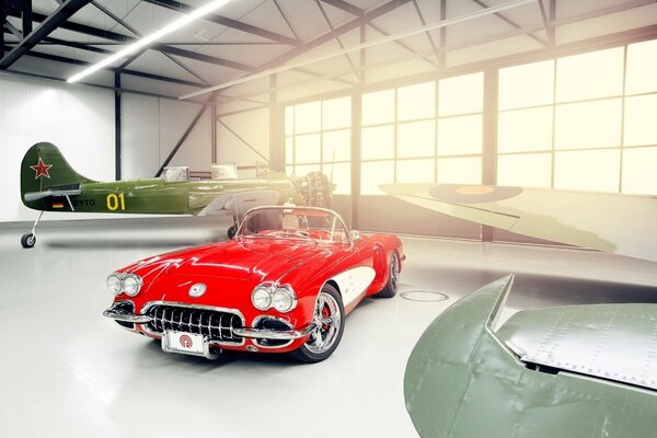 A red Chevy in a hangar with planes