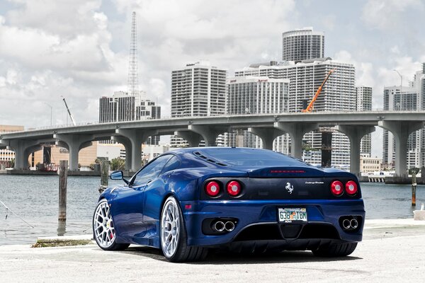 Blue Ferrari in the city by the bridge