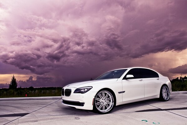 Schicker weißer BMW vor dem Hintergrund des violetten Himmels und der Wolken