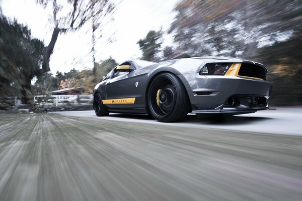 Muscle car silver mustang rushes at speed