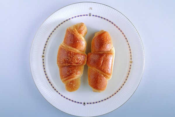 Croissant su un piatto bianco. Immagine di sfondo