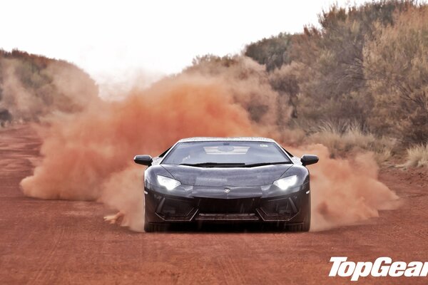 A beautiful car is driving along a dusty road