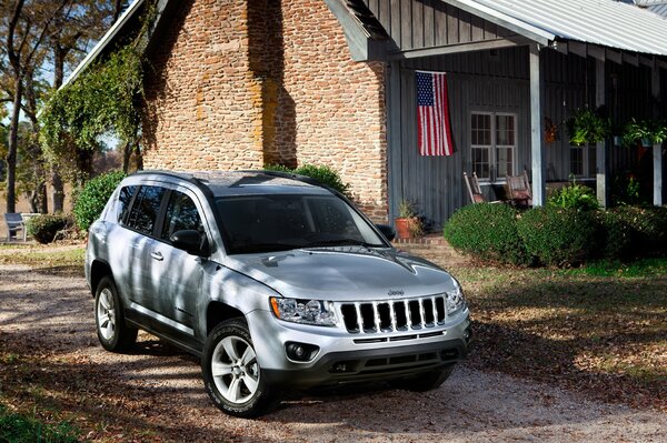 Jeep plateado en la casa de ladrillo