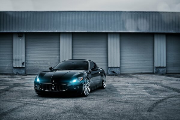 Maserati nero. Sfondo grigio. Cerchi in lega