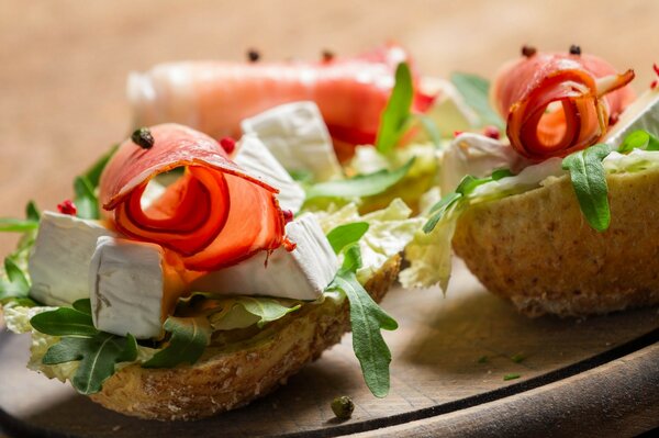 Vorspeise in Form eines Bootes aus Brot mit Käse, Schinken und Kräutern