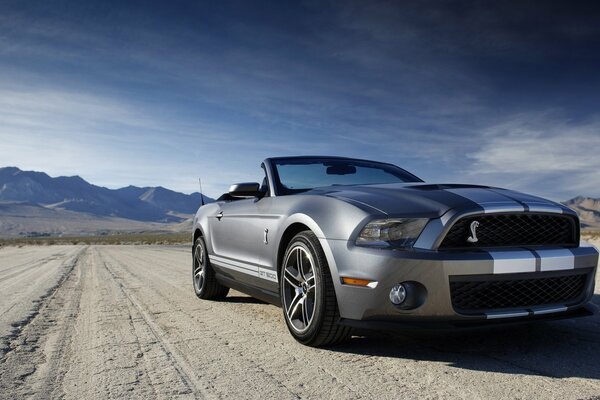 Coche Ford convertible en el fondo de las montañas