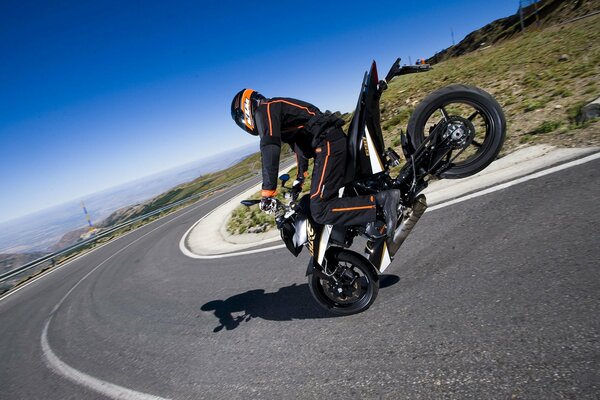 Motorcyclist on a motorcycle standing on the front wheel