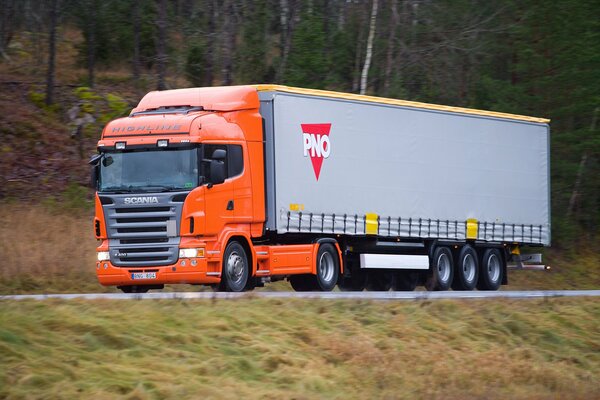 Enorme camión Scania monta en la carretera